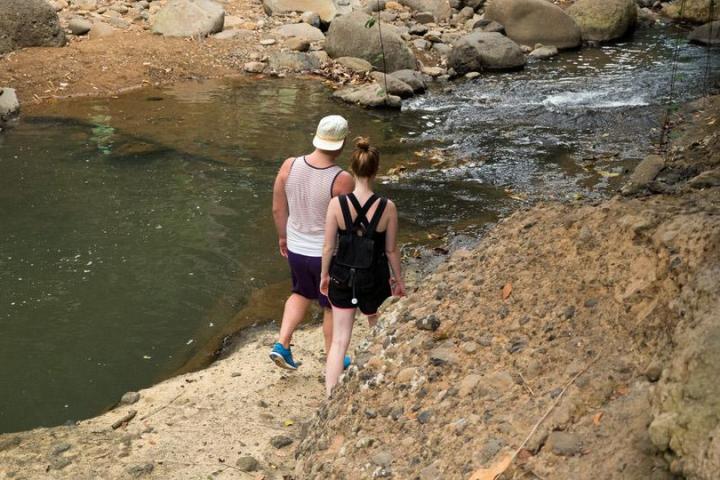 a couple walking along a riverbank