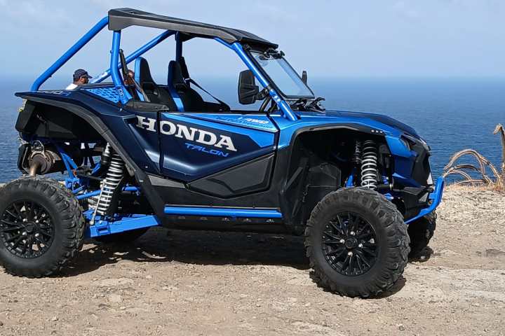 a blue truck driving down a dirt road